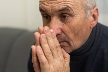 Lütfen, Tanrım. Endişeli, yaşlı, beyaz bir adam evdeki kanepede dua ediyor. Stresli beyaz Avrupa vatandaşı koltukta oturuyor, af diliyor ya da zor bir durumda Tanrı 'dan yardım diliyor.