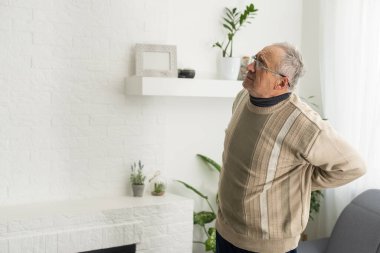 an elderly man has a backache.