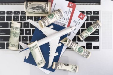 Composition with laptop, toy plane, money and passport on map. Travel agency and ticket booking concept