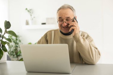 Pensive Senior Man Using Laptop Sitting At Home, Empty Space.