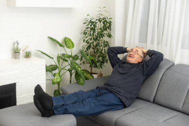 an elderly man is resting at home.