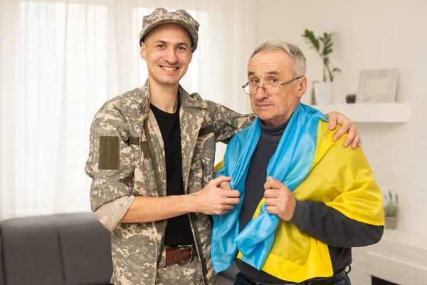 stock image elderly father and son military flag of Ukraine.