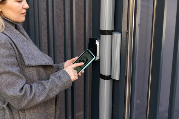 Женщина Стоит Двери Запирает Помощью Онлайн Приложения Своем Смартфоне — стоковое фото