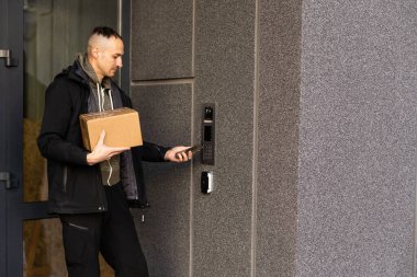 Binanın girişinde kameralı bir adam var.