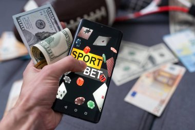 Smartphone with gambling mobile application, ball and money banknotes. Sport and betting concept. clipart