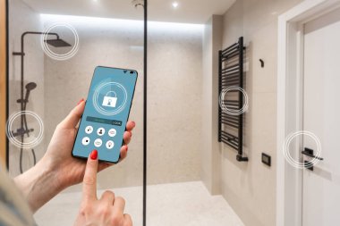 Akıllı ev telefonu, akıllı ev telefonu uygulama arayüzü cep telefonu ekranında, modern apartmandaki tüm ev sistemini telefonla kontrol eden genç bir kadın, konsept internet.