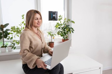 Yüksek bina açık havada elektrikli süpürge robot temizleme penceresi. genç kadın uzaktan kumanda