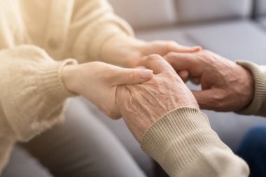 Genç fizyoterapistle rehabilitasyon işlemine katılan yaşlı bir erkek emeklinin başından vurulmuş. Yürüme engelli emekli bir adam profesyonel yardıma minnettar.
