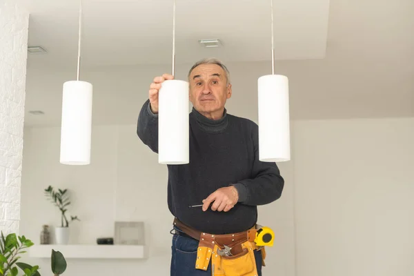 기술자가 천장에 전구를 바꾼다 가족의 의무를 가정에서 기구를 관리하는 — 스톡 사진