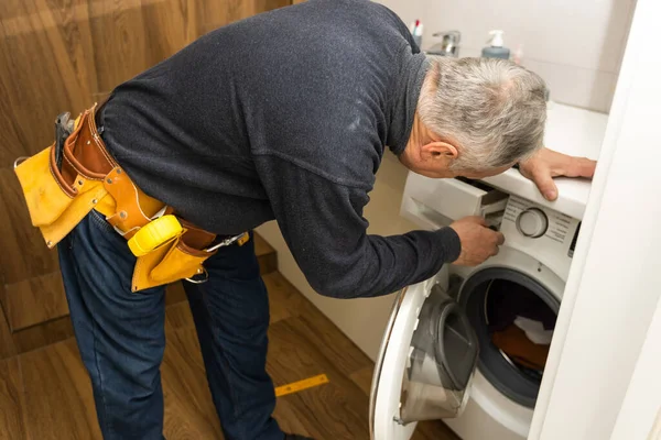 Elderly Man Repairs Washing Machine — Fotografia de Stock