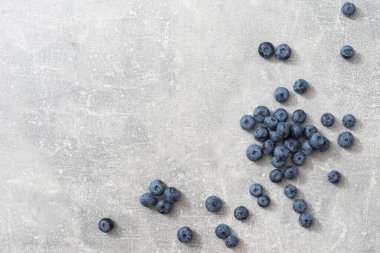 Gri arkaplanda bir grup taze yaban mersininin üst görüntüsü