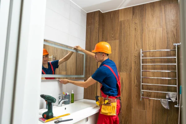 Male Repairman Hangs Modern Electronic Bathroom Mirror Accessories Furniture Bathrooms — Zdjęcie stockowe