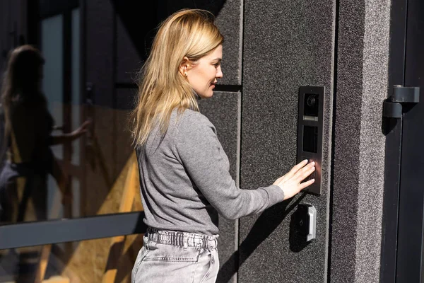 Ευτυχισμένη Γυναίκα Χτυπάει Κουδούνι Στην Είσοδο Του Κτιρίου Χρήση Ενδοεπικοινωνίας — Φωτογραφία Αρχείου