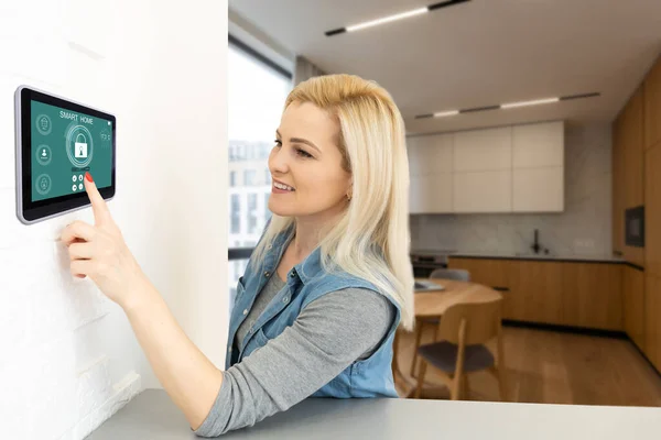 pretty blonde woman using smart home control panel .