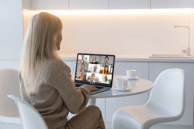 Back view of business woman talking about sale report in video conference. team using laptop and tablet online meeting in video call. Working from home, Working remotely and Self isolation