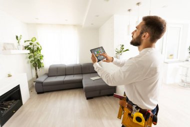 Onarım, inşaat ve yapı konsepti - mutlu gülümseyen işçi veya tablet bilgisayar ve araçlar ile inşaatçı