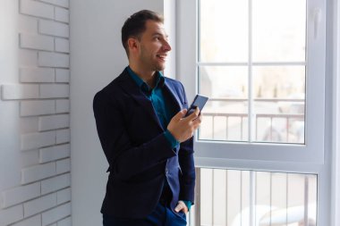 Boş ofislerdeki paketlerin yanında duran genç bir adamın portresi.