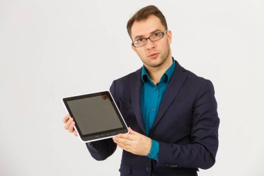 Tablet bilgisayar tutan ve beyaz arka planda izole kameraya bakan ciddi bir işadamının portresi