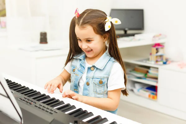 아름다운 거실이나 학교에서 피아노를 있습니다 자녀는 연주법을 배우는 재미있게 여긴다 — 스톡 사진