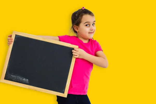 亚洲小女孩 背景是黄色的 手里拿着黑板 — 图库照片