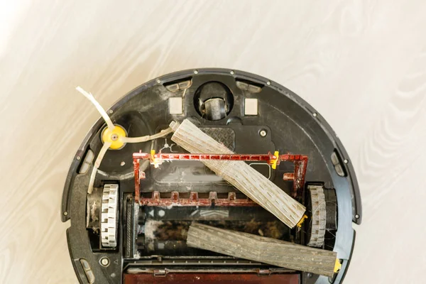 The round robot vacuum cleaner collapsed on the floor. The vacuum cleaner washer is broken. Repair of household appliances