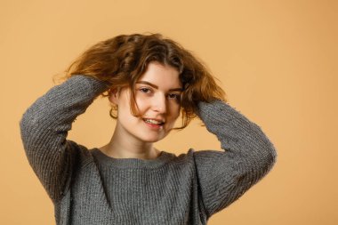 Tatmin olmuş genç bir kadının portresi dinleniyor ve kameraya bakıyor.