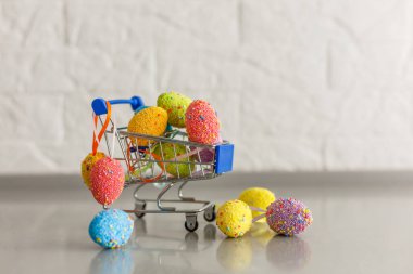 On the table small cart with Easter eggs