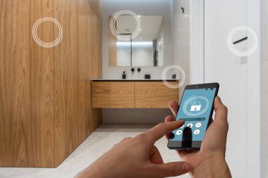 Akıllı ev, ev otomasyonu, uygulama simgeli aygıt. Kadın akıllı telefonunu akıllı güvenlik uygulaması ile evinin kapısını açmak için kullanıyor.