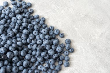 Gri arka planda çiğ organik yaban mersini. Boşluğu kopyala