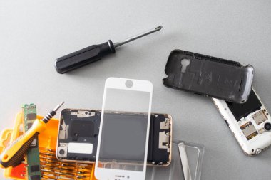 Teknisyen, cep telefonunun içinde lehim kullanarak tamir ediyor. veri kavramı, donanım, teknoloji