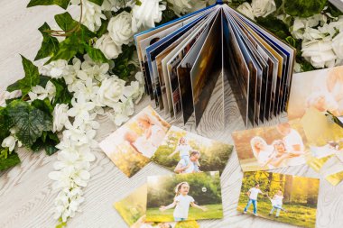 printed photos of family summer vacation lying on desk