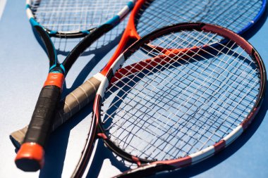 broken tennis rackets on clay tennis court.