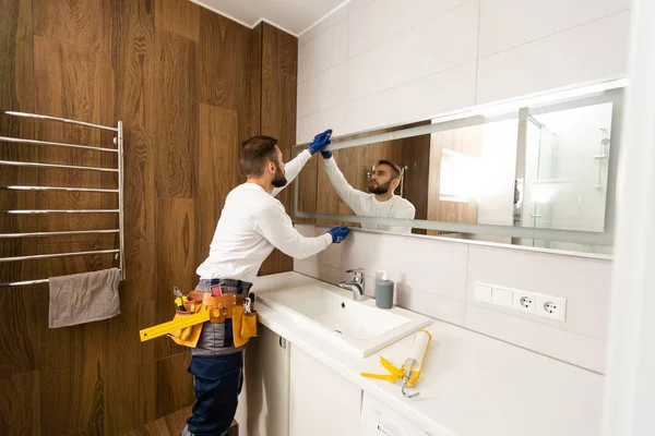 Mann Montiert Spiegel Wand Seines Erneuerten Badezimmers — Stockfoto