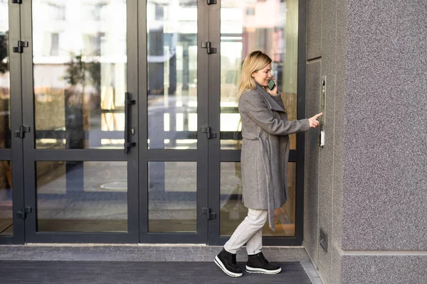 Bir Kadın Akıllı Telefon Kullanarak Giriş Kapısına Akıllı Kilit Takıyor — Stok fotoğraf