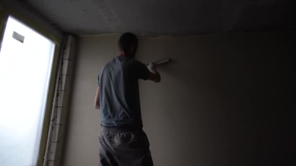 建筑工人穿工人整体与墙面抹灰工具修复的公寓房子 泥水匠整治室内墙壁和天花板与浮法和石膏 涂饰工程的施工 — 图库视频影像