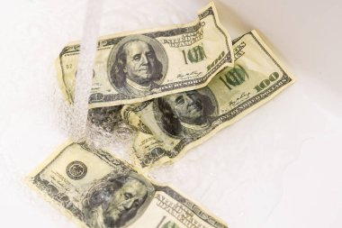 Para lavaboya atılır. Bu fotoğraf konsepti batmakta olan ya da batmakta olan bir şirketin finansal durumunu gösteriyor. Bu yüzden para sadece sonuçsuz yere harcanıyor..