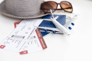 Pasaport şapkası güneş gözlükleri ve arka planda oyuncak uçak.