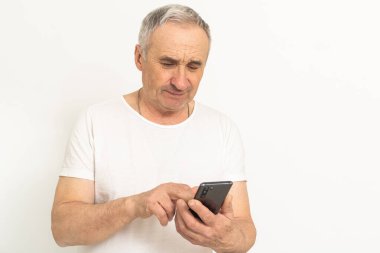 an elderly man uses a smartphone.