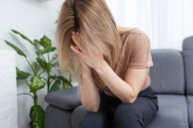 Güzel bir gencin portresi. Şakaklarına dokunuyor. Gri arka planda stres hissediyor..