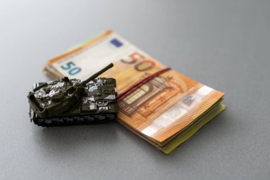 Ekonomik kriz konsepti. Avro banknotları üzerinde oyuncak askeri tank. Ukrayna 'daki savaş çatışmaları, ekonomik yaptırımlar ve enflasyon.