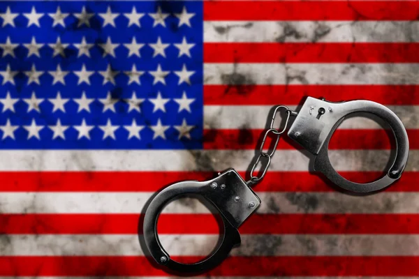 USA flag and police handcuffs. The concept of crime and offenses in the country. the concept of crime in the state or government of the country. High quality photo