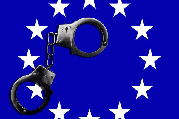 FreedomHandcuff on the flag of European Union. Flag of European Union and handcuffs, European Union law concept. Closeup, copy space for text. High quality photo