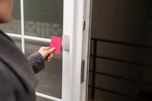 stock image Woman attaches card to the electronic reader to access the apartment. Card entry, personal identification, keyless access, technologies in everyday life