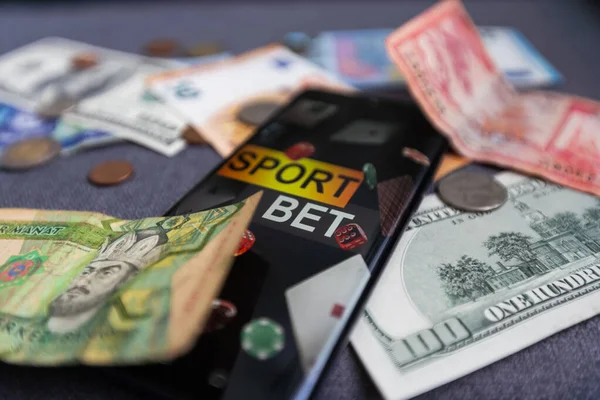 stock image dollars and euros, smartphone with sports bet application.