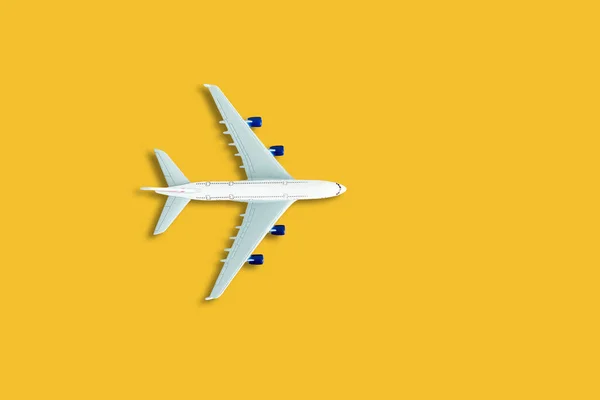 Flat lay design of travel concept with plane on yellow background with copy space. High quality photo