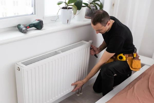 Repair heating radiator close-up. man repairing radiator with wrench. Removing air from the radiator. High quality photo