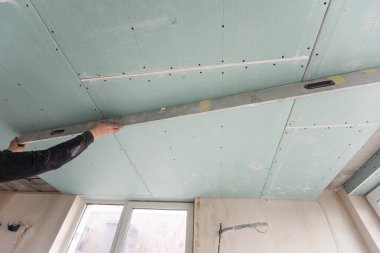 Adam alçı tavanlar için metal çerçeve monte ediyor. Yüksek kalite fotoğraf