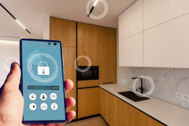 İnternet, akıllı ev, mutfak ve ağ bağlantısı konsepti. İnsan eli telefonu ve mutfak geçmişi bulanık olan güç kullanımını saymak için akıllı ev uygulaması..