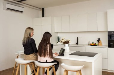 Anne ve kızı dijital cihazlar kullanarak.