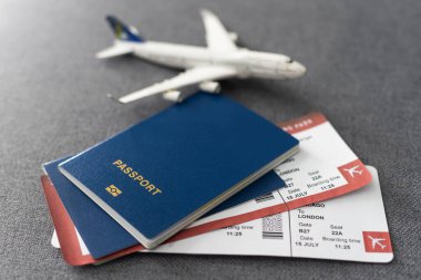 Uçak biletleri, Pasaportlar ve masada oyuncak uçak.